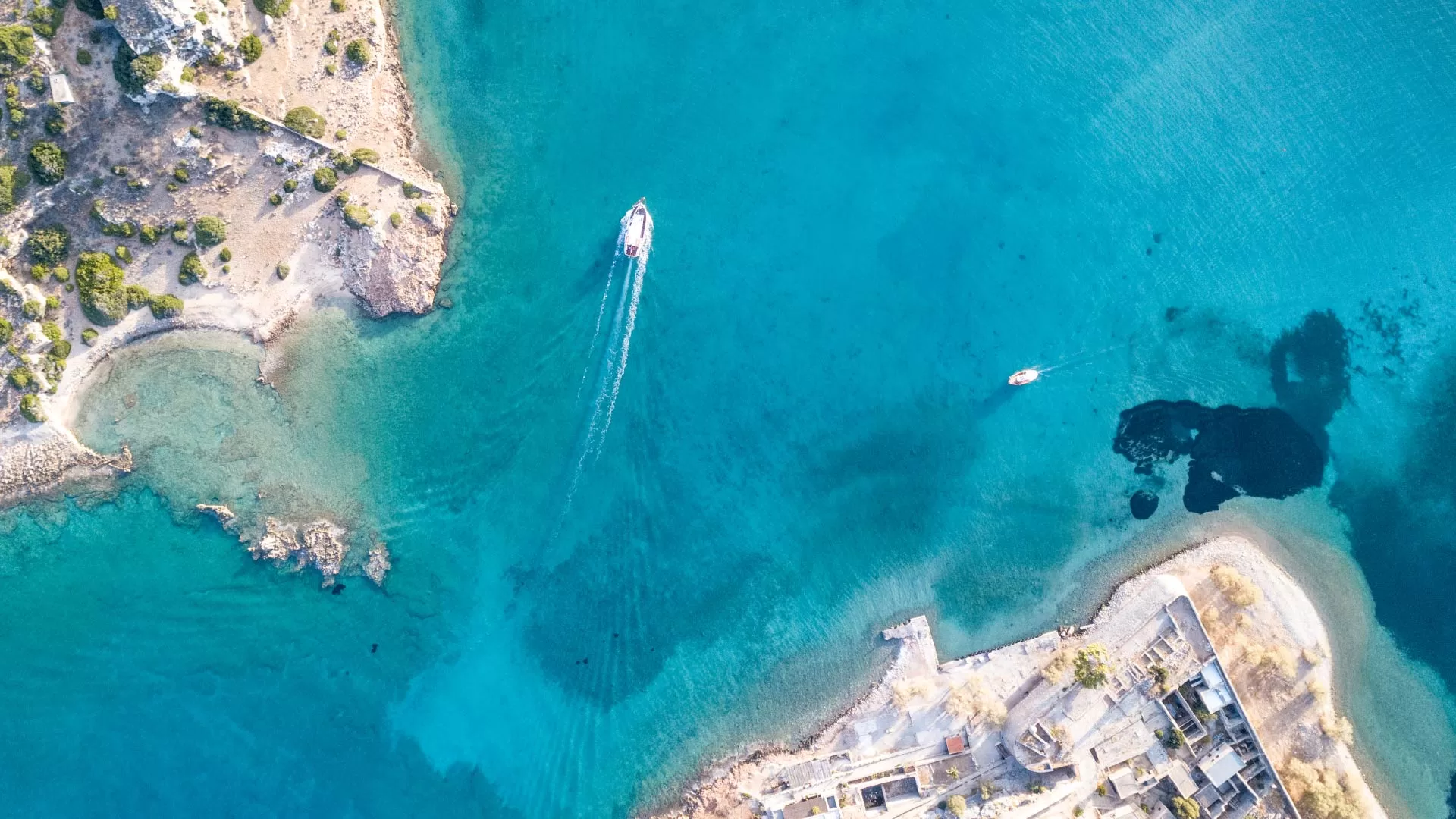 Αεροφωτογραφία παραλίας και θάλασσας με σκάφη που μεταφέρουν τουρίστες σε παραθαλάσσια περιοχή.