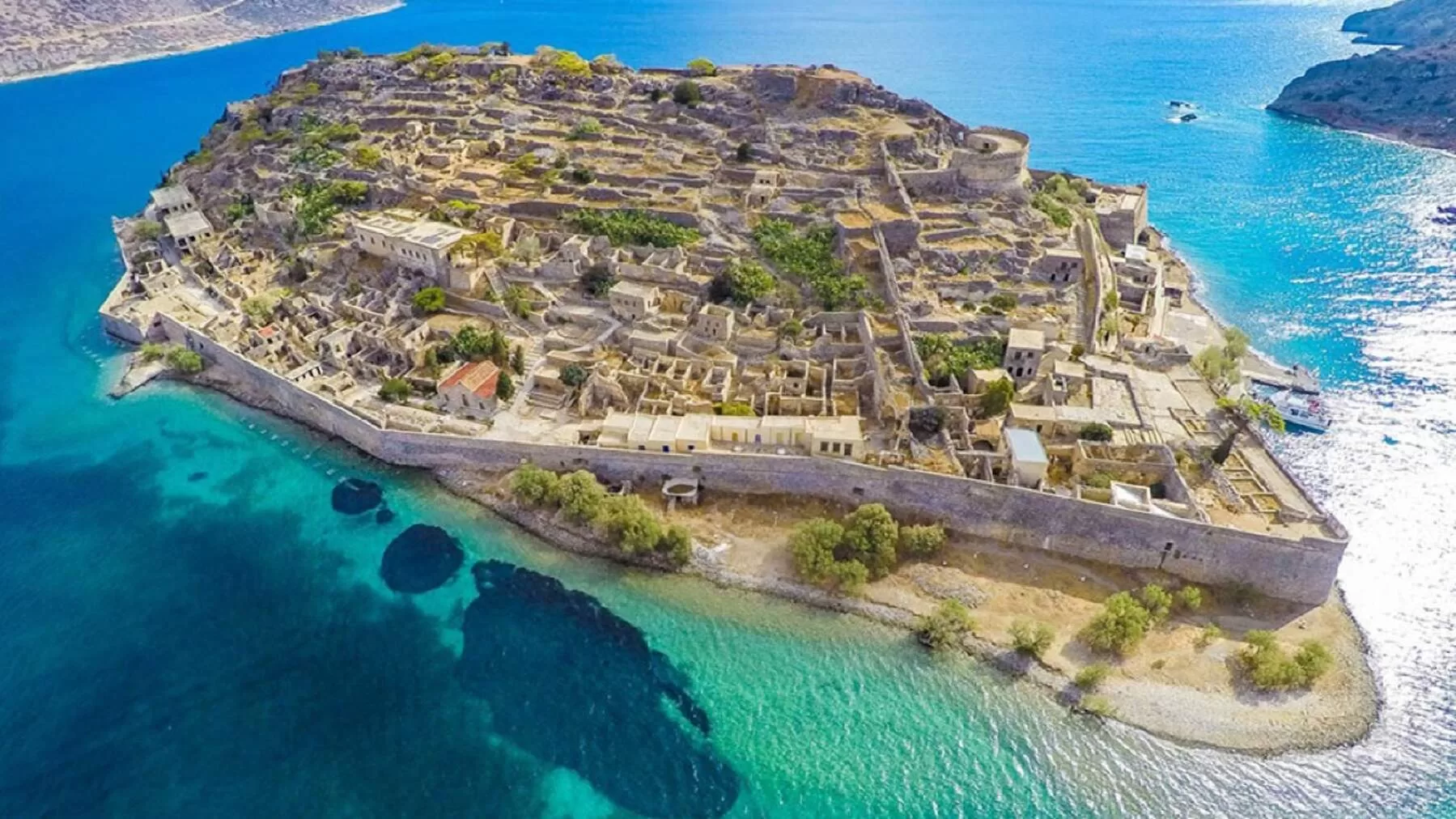Aerial view of Spinalonga Island in Crete – a historic fortified islet in the Gulf of Mirabello, a popular tourist attraction with Venetian walls and crystal-clear waters.