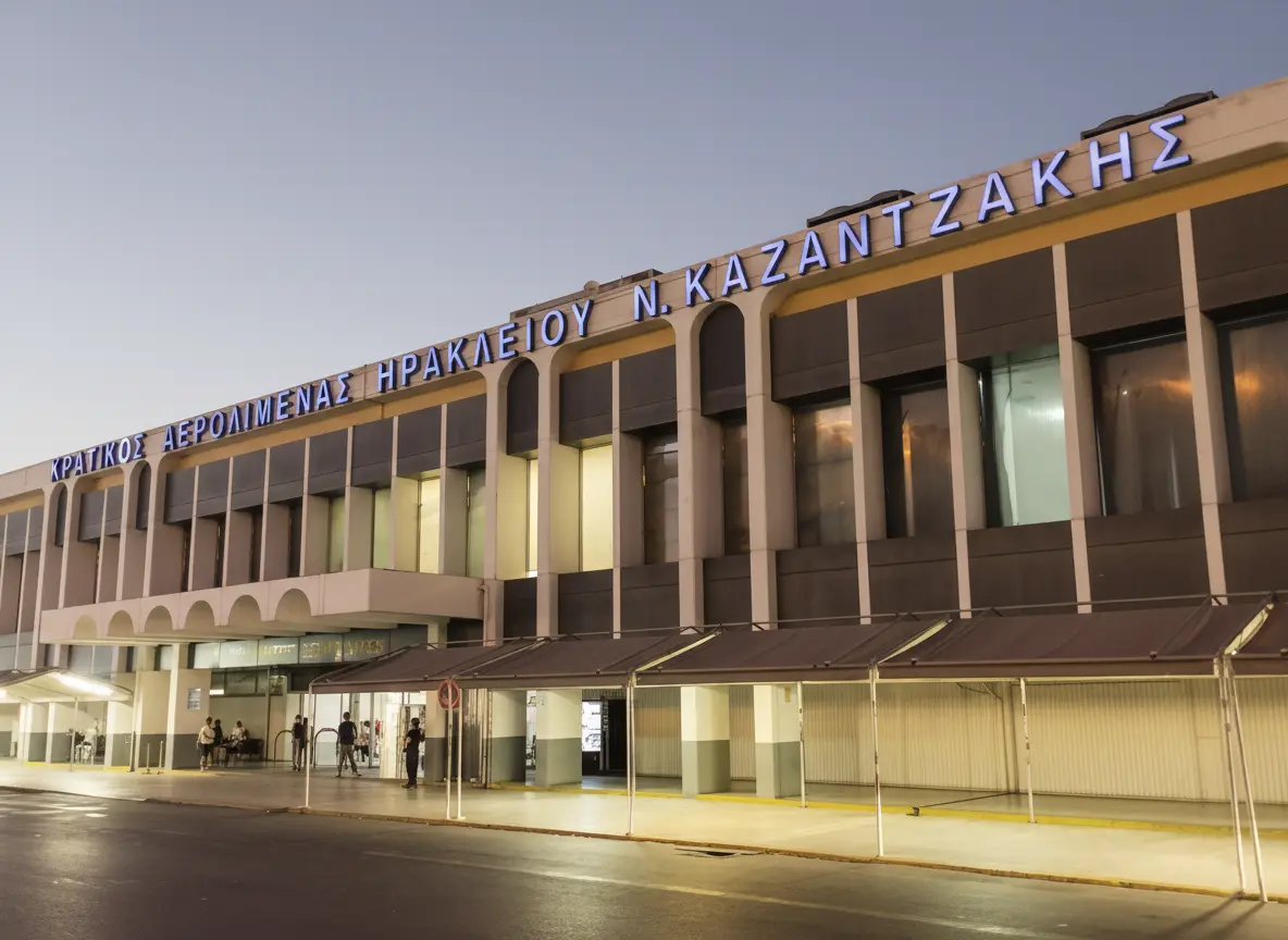 Versatours driver waiting with a name sign in the arrivals hall at Heraklion Airport